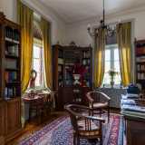 Superando quella di sinistra accediamo a uno studio con eleganti librerie in legno disposte ai quattro angoli...